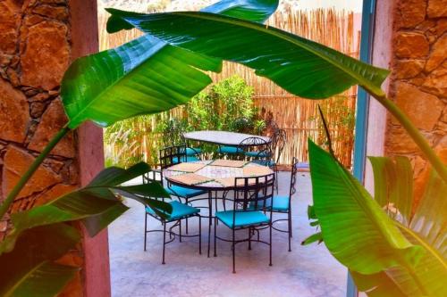 a patio with tables and chairs and a plant at HoneyPath Atlas Retreat in Agadir