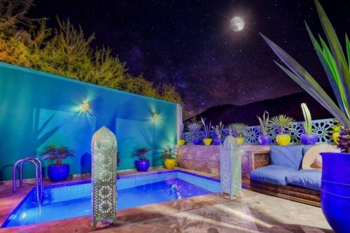 a patio with a couch and a pool at night at HoneyPath Atlas Retreat in Agadir