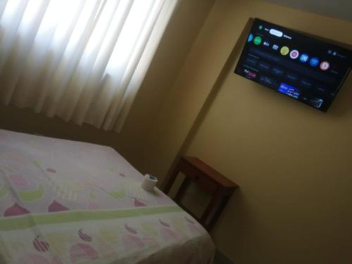 a bedroom with a bed and a tv on the wall at Hospedaje San Valentin in Capitan Concha