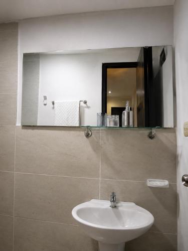 a bathroom with a sink and a mirror at Hostal Caiman Del Rio in Barranquilla