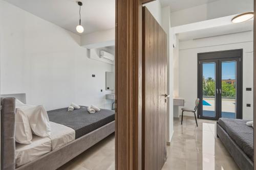 a bedroom with a bed and a view of a pool at Aurelia Luxury House in Amoudara Herakliou