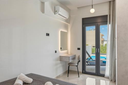 a bedroom with a bed and a desk and a chair at Aurelia Luxury House in Amoudara Herakliou