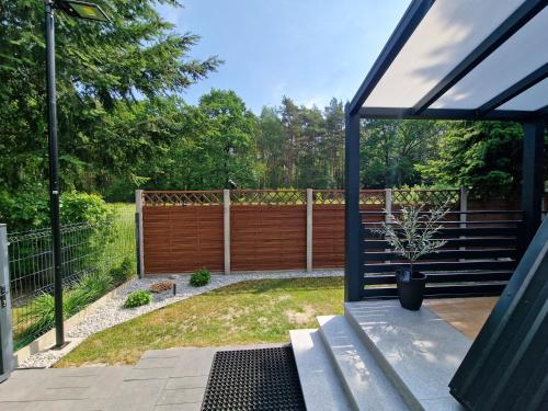 a patio with a bench and a fence at Bukowy Domek Całoroczny in Sieraków