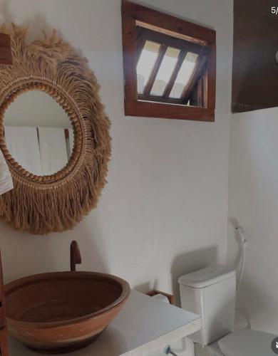 a bathroom with a sink and a mirror on the wall at Vila Maré Alta Caraiva in Caraíva