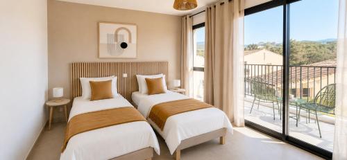 two beds in a hotel room with a balcony at Résidence Saint Flor in Saint-Florent