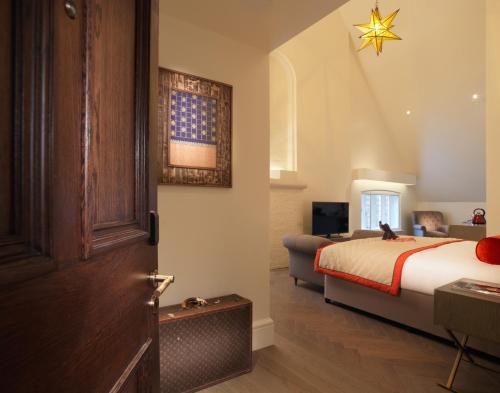 a hotel room with a bed and a door at The LaLit London in London