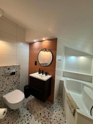 a bathroom with a sink and a tub and a toilet at Camper Park Radków - domki i pokoje in Radków