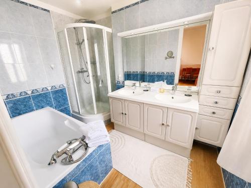 a bathroom with two sinks and a tub and a shower at Le Lierre et La Rose in LʼAigle