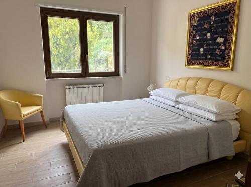a bedroom with a bed and a chair and a window at Villa Nina in Caporciano