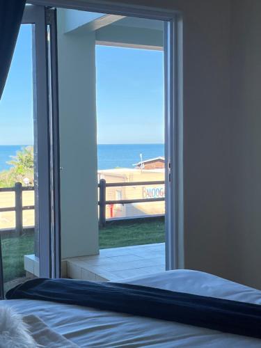 a bedroom with a view of the ocean through a sliding glass door at Stay Joy coastal in Margate