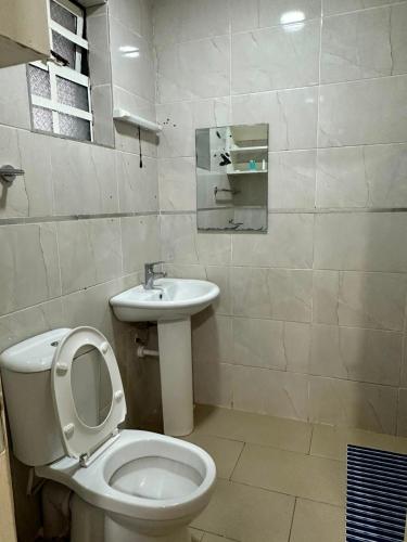 a bathroom with a toilet and a sink at Entebbe Gardens Resort in Kitengela 