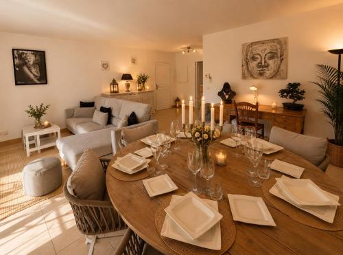 a living room with a dining room table with candles at Le Aix Rotonde Mirabeau - Centre Ville Terrasse Garage in Aix-en-Provence