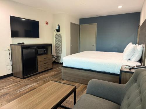 a hotel room with a bed and a tv at Baymont by Wyndham Manteca in Manteca