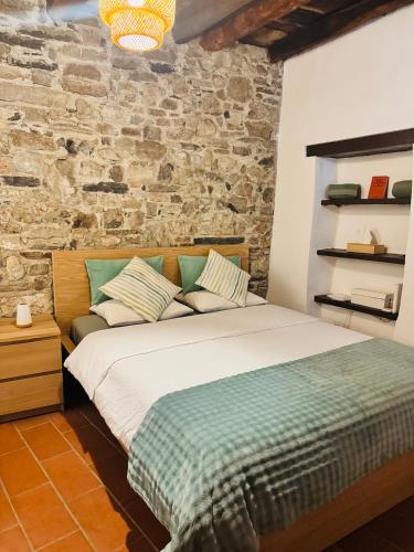 a bedroom with a bed and a brick wall at Dolce Notte - Rustico a Gandria in Lugano