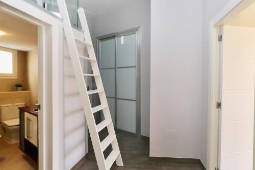 a white staircase in a room with a bathroom at Apartamentos Calle Larios in Málaga