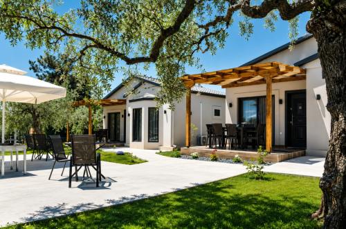 a patio with a table and chairs in a yard at Aivazidis Residence II in Skala Kallirachis