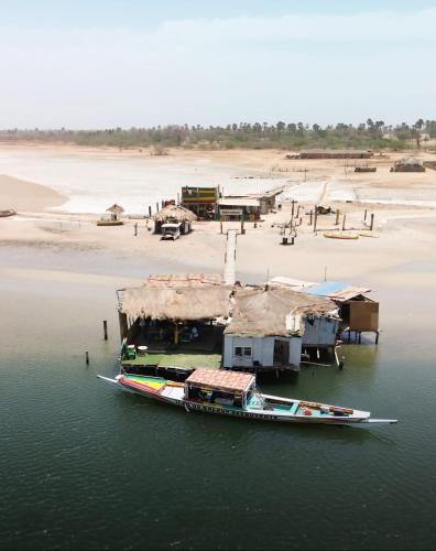 a boat in the water next to a beach at La Cabane Rasta - Mar Lodj in Mar Lodj