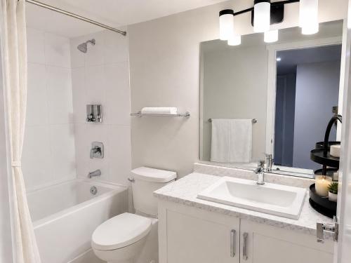 a white bathroom with a toilet and a sink at Cozy South Surrey Private Suite 1 Bedroom - 2 Beds - Separate Entrance in Surrey