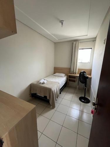 a small bedroom with a bed and a window at Hotel Piracema in Caruaru