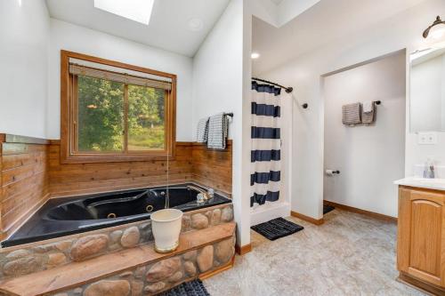 a jacuzzi tub in a bathroom with a window at Aces and Eights Lodge in Sturgis