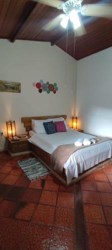 a bedroom with a large bed with two lamps at Hospedagem Vista Real in Casa Branca