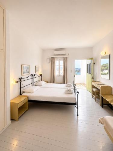 a large white bedroom with two beds and a desk at SPITIA VASILI in Kapsali
