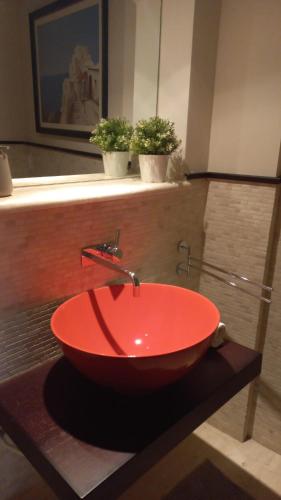 a red bowl sink on a counter in a bathroom at Corso Garibaldi in San Salvo