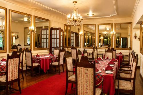 a dining room with tables and chairs and a chandelier at Hotel Aranjuez Cochabamba in Cochabamba
