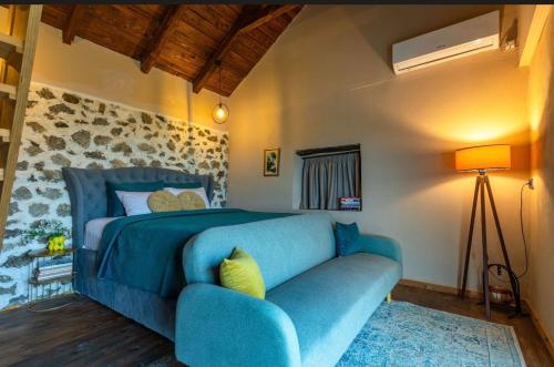 a blue couch in a bedroom with a bed at The Stonehouse in Ulcinj