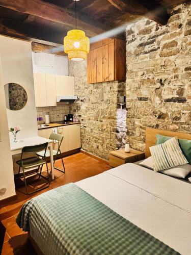 a bedroom with a bed and a table and a kitchen at Dolce Notte - Rustico a Gandria in Lugano