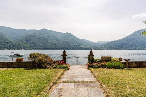 a gate leading to a lake with mountains in the background at Lakeside Paradise Porlezza in Cima