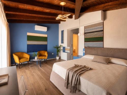a bedroom with a large bed and a desk and chairs at Astra - Exclusive Rooms in Castelsardo