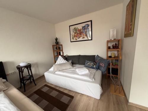 a living room with a white couch in a room at Bright studio-flat near station - Bayreuth in Bayreuth