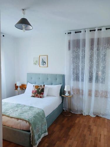 a bedroom with a bed with a blue headboard and curtains at Mountain View Guest House,Geres in Geres