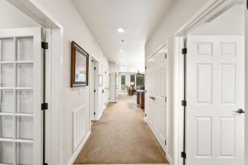 a hallway with white walls and doors and a hallwayngth at Salmon Run Condo - Overlooking the Spokane River in Post Falls