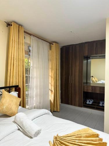 a bedroom with a bed and a large window at Entebbe Gardens Resort in Kitengela 