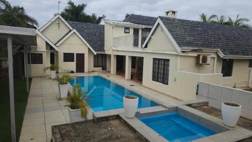 a house with a swimming pool in front of a house at 3D Power guest house in Durban