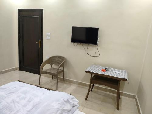 a room with a bed and a table and a tv at Egyptian guest house in Cairo