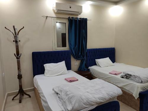 a room with two beds with blue chairs and a mirror at Egyptian guest house in Cairo
