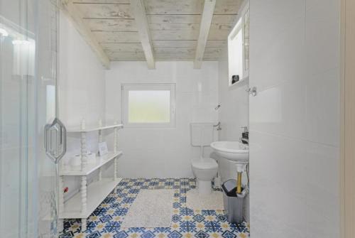 a white bathroom with a toilet and a sink at Apartments on island Molat next to the sea - by TA Leut Agency in Brgulje