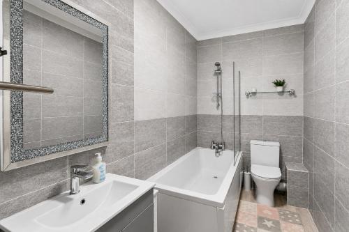 a bathroom with a tub and a sink and a toilet at Spacious two bedroom flat in Lansdowne in Bournemouth
