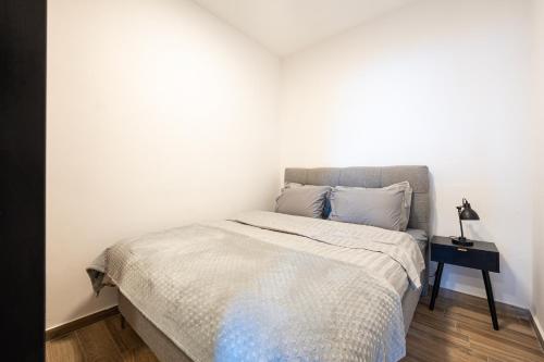 a bed in a bedroom with a white wall at Rezevici Horison View Apartment in Reževići