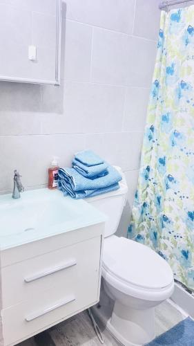 a bathroom with a white toilet and a shower curtain at crown y key in Ciales