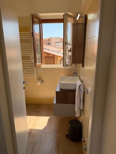 un piccolo bagno con lavandino e finestra di Giusti Mare a Grosseto