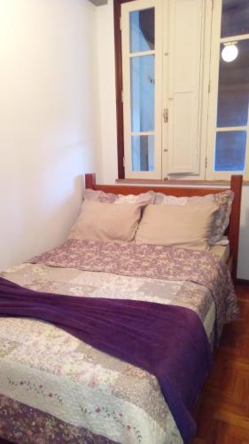 a bed sitting in a room with a window at Flat - Condomínio Summerville Apart in Miguel Pereira