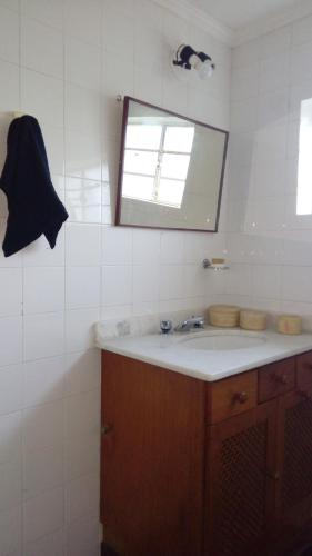 a bathroom with a sink and a mirror at Flat - Condomínio Summerville Apart in Miguel Pereira