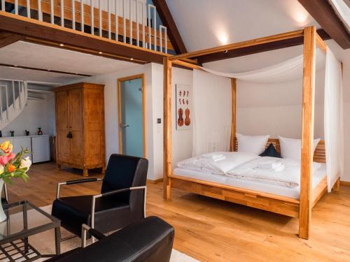 a bedroom with a bed and a chair in a room at Villa Stradivari - Black Forest with Alpine views in Lenzkirch