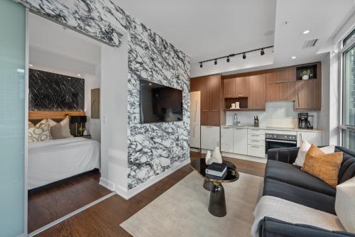 a living room with a bed and a kitchen at NoMad Suites - Toronto's Entertainment District in Toronto