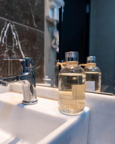a bottle of soap sitting on a bathroom sink at Il Divo Boutique Hotel in Ciudad del Este