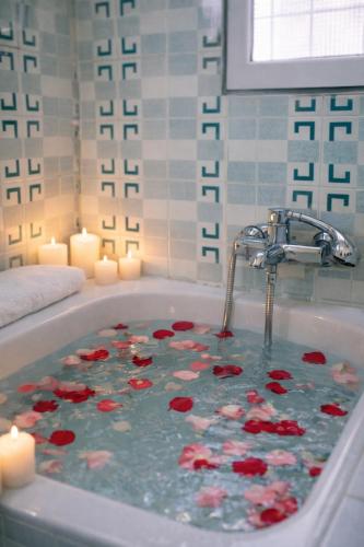 a bath tub filled with red roses and candles at Corinth Central Studio in Korinthos